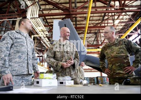 Von links, US Air Force Staff Sgt. Markieren Birrenkott, 58th Aircrew Maintenance Squadron CV-22 Osprey Avionik Handwerker und US Air Force Tech. Sgt. Derek Scott, 58. AMXS CV-22 Osprey Crew Chief spricht mit US Air Force Generalmajor Mark E. Weatherington, Bildung und Ausbildung Kommando Kommandant Stellvertreter, in Kirtland Air Force Base, N.M., Jan. 11, 2019. Birrenkott und Scott zeigte Weatherington ihre innovative Idee auf, wie zurück zu schneiden Reinigung Zeit auf die CV-22 Osprey. Stockfoto