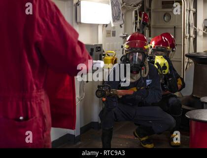 Mittelmeer (Feb. 11, 2019) Segler Kampf einen simulierten Brand während ein General Quarters bohren an Bord der San Antonio-Klasse amphibious Transport dock Schiff USS Arlington LPD (24), 24.02.11, 2019. Arlington ist auf einem geplanten Einsatz als Teil der Kearsarge Amphibious Ready Gruppe zur Unterstützung der Maritime Security Operations, Krisenbewältigung und Theater Zusammenarbeit im Bereich Sicherheit und zugleich eine Vorwärts naval Präsenz. Stockfoto