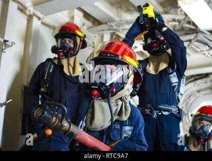 Mittelmeer (Feb. 11, 2019) Segler Kampf einen simulierten Brand während ein General Quarters bohren an Bord der San Antonio-Klasse amphibious Transport dock Schiff USS Arlington LPD (24), 24.02.11, 2019. Arlington ist auf einem geplanten Einsatz als Teil der Kearsarge Amphibious Ready Gruppe zur Unterstützung der Maritime Security Operations, Krisenbewältigung und Theater Zusammenarbeit im Bereich Sicherheit und zugleich eine Vorwärts naval Präsenz. Stockfoto