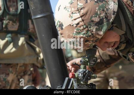 Ein Soldat mit 10 den Jordan Bundeswehr Bundesgrenzschutz Kraft sieht durch das Schauglas Einheit auf einem M252 81 mm Mörser system und die endgültige Einstellung vor der Waffe abfeuern während der Jordan operativen Engagement Program am 13.02.2019 ausserhalb von Amman, Jordanien. Als 1. der Oregon National Guard Squadron, 18 Cavalry Regiment weiterhin zu trainieren Seite an Seite mit Soldaten der JAF, Soldaten in der Lage sind, ein gemeinsames Verständnis der jeweiligen Verfahren unter Einsatz des Direct-lay Engagement Technik zu bauen. Die gemeinsame - Mörser Teams waren in der Lage, effektiv zu kommunizieren und e Stockfoto