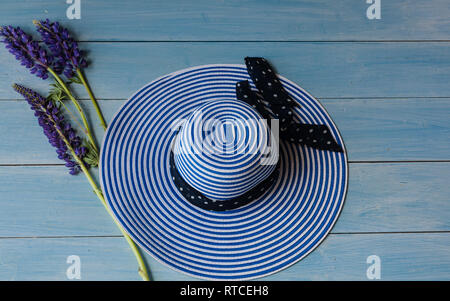 Women's Hut Blumenstrauß aus Lupinen blau Holz- Hintergrund Stockfoto