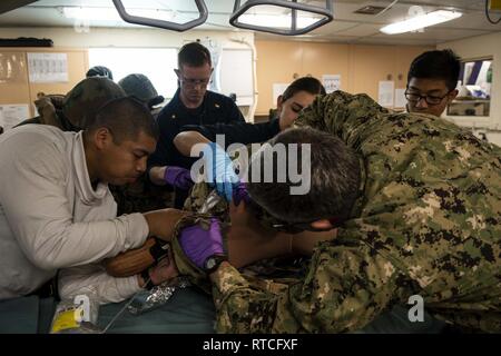 Golf von Thailand (Feb. 16, 2019) - Segler, die amphibious Transport dock Schiff USS Green Bay LPD (20) einen simulierten Patienten während eines Unfalls Evakuierungsübung mit der Royal Thai Navy bewerten. Green Bay, Teil der Wasp amphibischen bereit, Gruppe, mit Eingeschifft 31 Marine Expeditionary Unit (MEU), in Thailand, die in der Übung Cobra Gold 2019 zu beteiligen. Cobra Gold ist eine multinationale Übung von Thailand und den Vereinigten Staaten gefördert werden, ist entworfen, um die regionale Sicherheit und wirksame Reaktion auf die Krise Kontingenzen durch ein robustes multinationale Truppe vorzurücken Comm zu Adresse Stockfoto