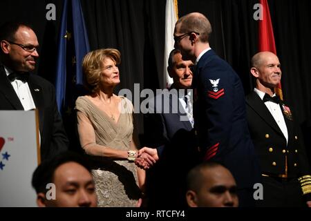 Coast Guard Petty Officer 2nd class Lucas Ellis, zugewiesen, Coast Guard Sektor Anchorage schüttelt Hände mit Alaska Sen. Lisa Murkowski während der 42 Armed Services YMCA Gruß zu den Militärs in Anchorage, Alaska, Feb 16, 2019 statt. Ellis ist Alaska's Coast Guard Reservist des Jahres. Us-Küstenwache Stockfoto