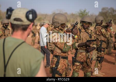 Eine tschechische Special Forces Soldat beobachtet Malischen Soldaten, wie sie M 9 Pistolen während einer live Feuer Bereich in der Nähe von Loumbila, Burkina Faso Feb 17, 2019 klar. Die Schulung ist Teil der Übung Flintlock 19 und stellt sicher, dass die malischen Soldaten beherrschen mit ihren Waffen. Flintlock US Africa Command's Premier und größte Special Operations Forces Übung in Afrika. Stockfoto