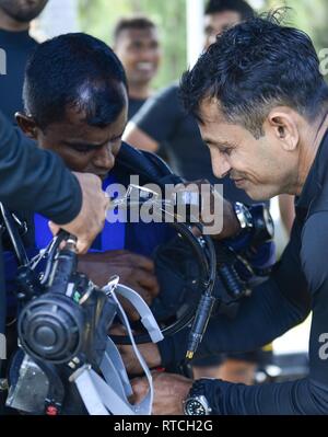 SANTA Rita, Guam (Feb. 19, 2019) Eine Sri Lankan navy Diver hilft dem anderen seine Tauchausrüstung während des Trainings zu Don, in Vorbereitung auf die Übung Zusammenarbeit flott Bereitschaft und Weiterbildung (Karat), Sri Lanka, 19. Diese pre-übung Training wurde konzipiert, um die Sri Lankan Mannschaft mit Ausrüstungen und Praktiken, die bis zum Fall ab April vertraut zu machen. Stockfoto