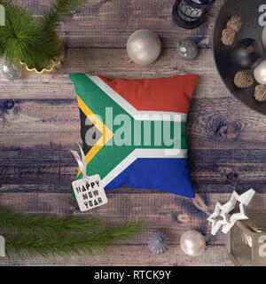 Frohes Neues Jahr Tag mit Südafrika Flagge auf Kissen. Weihnachtsdekoration Konzept auf Holztisch mit schönen Objekte. Stockfoto