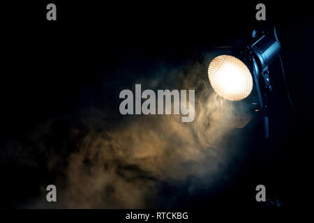 Gelbe Leuchte mit Rauch auf dunklem Hintergrund. Ausrüstung für Photo Studio. Stockfoto