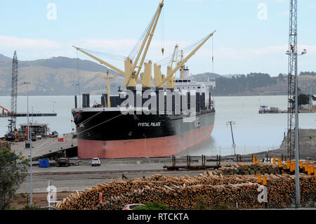 Ein Frachtschiff seine Last von Holz im Log Yard in Lyttleton Hafen von Christchurch, Neuseeland. Stockfoto