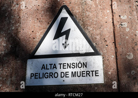 Electrocution schild Warnung vor der Gefahr eines elektrischen Schlags. Spanische Text 'Hohe Spannung Gefahr des Todes' Stockfoto