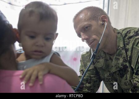 CALAMA, Brasilien (Feb. 14, 2019) Cmdr. Edmund Milder untersucht einen jungen Patienten im Benjamin Silva-Calama Klinik in Calama, Brasilien, 24.02.14. Der Besuch markiert den dritten Anschlag eines einmonatigen Mission von vier US-Marine ärzten und ihren brasilianischen Marine Gegenstücke an Bord der brasilianischen Marine Oswaldo Cruz-Klasse Krankenhaus Schiff NAsH Carlos Chagas (U 19) medizinische Fachkenntnisse auszutauschen und medizinische Versorgung zu isolierten Gemeinden entlang des Amazonas zu bringen. Stockfoto