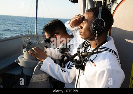 MUARA, Brunei (Feb. 15, 2019) Kulinarische Specialist 1. Klasse Angelo Dano (links) und Quartiermeister Seaman Joshua Davis, sowohl aus San Diego, Kalifornien, stand zusehen, wie ein Lager Abnehmer an Bord der Rächer - Klasse meine Gegenmaßnahmen USS Chief (MCM 14) Schiff, wie das Schiff zu Muara Naval Base Transite. Chef ist zu Besuch in Brunei während des Betriebs im US 7 Flotte die regionale Sicherheit und Stabilität zu stärken, und die Interoperabilität mit den Partnern verbessern. Stockfoto