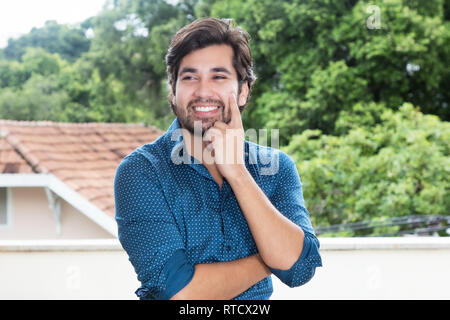 Stattliche Hispanic hipster Mann mit Bart im freien Raum mit kopieren Stockfoto