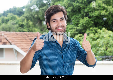 Hispanic hipster Mann mit Bart, Daumen hoch im freien Raum mit kopieren Stockfoto