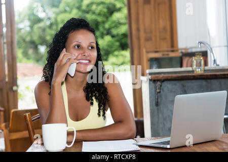 Schöne lateinamerikanischen Frau mit schwarzen Haaren flirten am Telefon Stockfoto