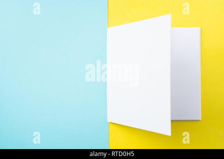 Designkonzept - Ansicht von oben öffnen Quadratische weiße Notebook auf bunten gelber und blauer Hintergrund für mockup Serie 4 Stockfoto