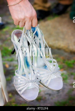 Die Braut trägt Ihr high-heeled Hochzeit Schuhe nach der Hochzeit bei Marshall Park in Ocean Springs, Mississippi. Stockfoto