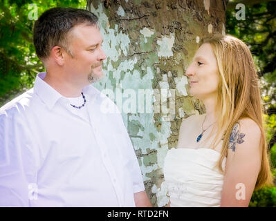 Eine junge Kaukasier Paar stellt für Portraits nach ihrer Hochzeit bei Marshall Park in Ocean Springs, Mississippi. Stockfoto