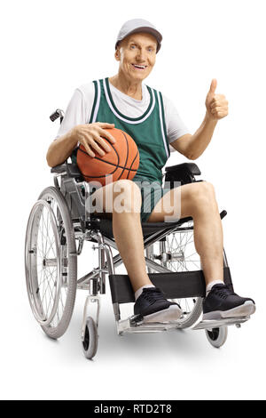 Behinderte ältere Mann im Rollstuhl mit einem Basketball und Daumen oben auf weißem Hintergrund Stockfoto