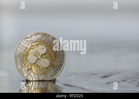 Ripple XRP Kryptowährung physische Münze im Wasser auf der Straße platziert Stockfoto