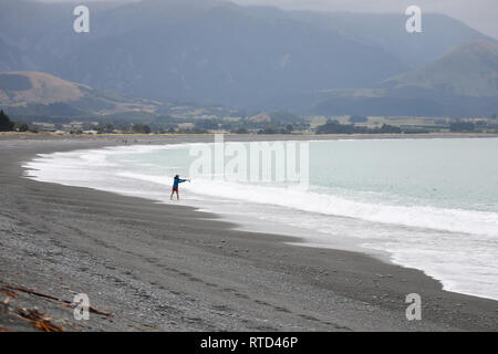 Fischer auf Kaikoura schwarz grau Kieselstrand mit Treibholz Neuseeland Südinsel Stockfoto