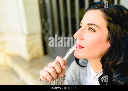 Reife Frau mit dunklen Haaren Denken besorgt sich Notizen mit einem Stift, kopieren. Stockfoto