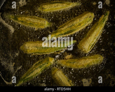 Gewürzt Okra braten in sauberes Öl gegen einen dunklen Hintergrund essen Foto Stockfoto