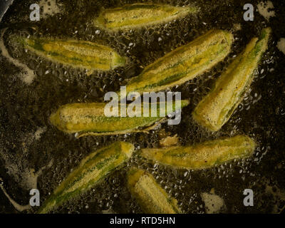 Gewürzt Okra braten in sauberes Öl gegen einen dunklen Hintergrund essen Foto Stockfoto