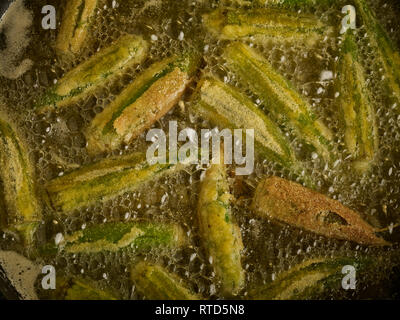 Gewürzt Okra braten in sauberes Öl gegen einen dunklen Hintergrund essen Foto Stockfoto