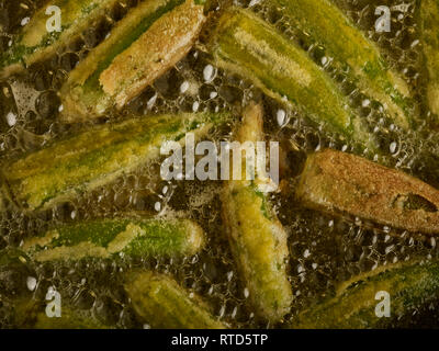 Gewürzt Okra braten in sauberes Öl gegen einen dunklen Hintergrund essen Foto Stockfoto