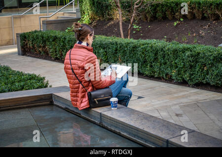 Junge Frau sitzt außerhalb Zeichnung im Innenhof außerhalb von Google UK Corporate Office in Kings Cross, London, England Stockfoto