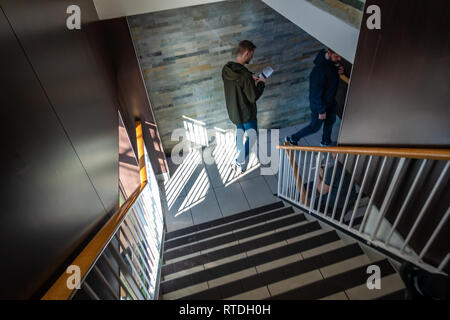 Männer auf der Treppe hinunter zu den Toiletten bei McDonalds in London, England Stockfoto