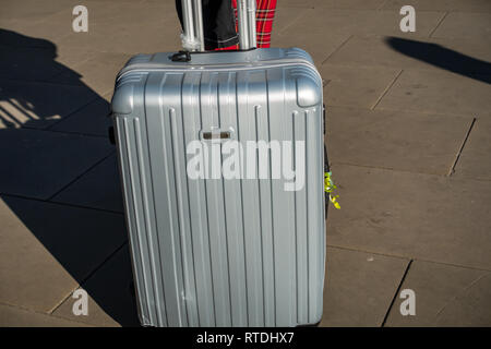 Junge Frau zieht sie zwei manoukian Luggage Set Aluminium Gehäuse aus Kings Cross Bahnhof, London, England Stockfoto