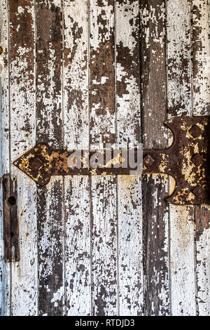 Detaillierte Nahaufnahmen der rostigen Scharniere an eine Tür mit abblätternder Farbe Stockfoto