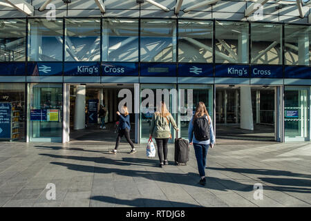 Ansicht der Rückseite des weiblichen Passagiere an der Außenseite des Kings Cross Bahnhof, London, England anreisen Stockfoto