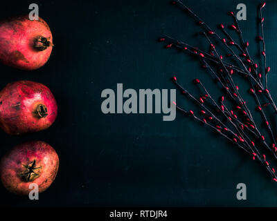 Seite Zeile der gesamte Granatäpfel auf schwarzen Hintergrund mit Kopie Raum Stockfoto