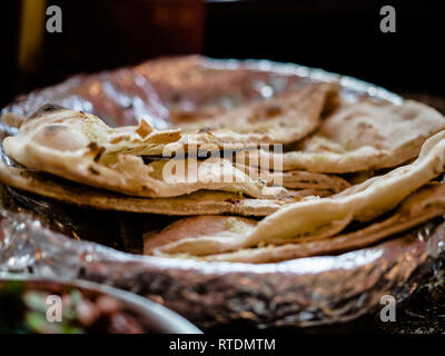 Indisches essen und indische Curry in einem Kupfer Messing serviert orientalische Schale, Hähnchenbrustfilet in Currysauce Zutaten in einen Topf mit der alten Tabelle Stockfoto