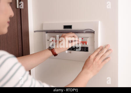 Hand einschließlich der Schalter auf dem Schaltkasten Stockfoto