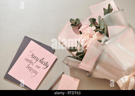 Geschenkbox, Wecker und rosa Rose Blüten am weißen Tisch Draufsicht in Flach Stil. Grußkarte für Mutter oder Frau Tag. Stockfoto