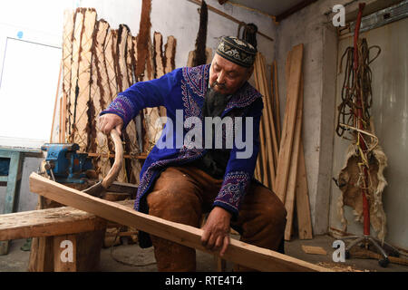 (190301) - ALTAY, März 1, 2019 (Xinhua) - Foto auf Jan. 16, 2019 zeigt Silanbek Sahshi eine Planke Planung in seiner Werkstatt in Altay, Nordwesten Chinas Autonomen Region Xinjiang Uygur genommen. Silanbek Sahshi, ein 65-jähriger Mann der Kazak ethnischen Gruppe, ist ein Erbe der traditionellen Fell - Snowboard in Xinjiang. Als vierte Generation der Erben des Handwerks und seiner Familie, Silanbek wurde im Handwerk für fast 50 Jahre engagiert. Das Fell Snowboards sind aus Kiefer oder Birke und bedeckt mit horsehide. Die horsehide können Reibung bieten, wenn Skifahrer bergauf gehen, wie die Maserung des Pferdes Stockfoto