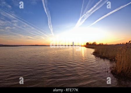 Code Streifen am Himmel über Schleswig bei Sonnenuntergang am frühen Abend im späten Winter. In Verschwörungstheorien, diese dünne Wolken durch Flugzeuge werden auch als Chemtrails bezeichnet. Chemtrail ist ein portmanteau der Englischen chemische für Chemikalien und Kondensstreifen für Kondensstreifen, in Deutscher Sprache, über chemische Streifen. Stockfoto