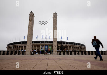 Berlin, Deutschland. 01 Mär, 2019. Die Olympischen Ringe am Osttor des Olympiastadion Berlin kann man mit einem Passanten vorbei. Credit: Christoph Soeder/dpa/Alamy leben Nachrichten Stockfoto