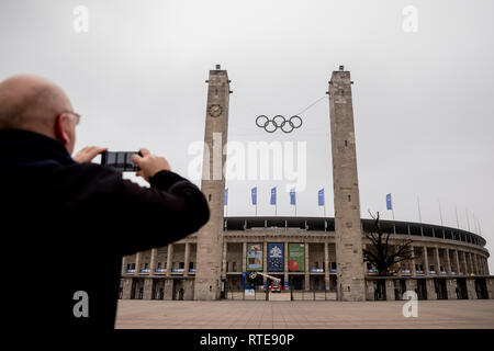 Berlin, Deutschland. 01 Mär, 2019. Ein Mann Fotografien das Berliner Olympiastadion mit der Olympischen Ringe am East Gate. In der Stadt, die Impulse für eine Neue Olympia-bewerbung durch die deutsche Hauptstadt hat heftige Diskussionen ausgelöst. Vor allem das Jahr 2036, in der Berliner Innen und Sport Senator Andreas Geisel (SPD) - genau 100 Jahre nach dem Sommer Spiele während der NS-Diktatur - stark diskutiert. Credit: Christoph Soeder/dpa/Alamy leben Nachrichten Stockfoto