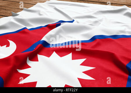 Flagge Nepal auf einem hölzernen Schreibtisch Hintergrund. Seide nepalesische Flagge Ansicht von oben. Stockfoto