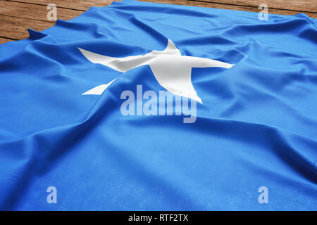 Flagge Somalia auf einem hölzernen Schreibtisch Hintergrund. Seide somalische Fahne Ansicht von oben. Stockfoto