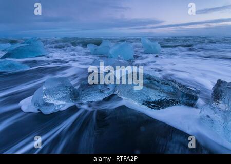 Eisbrocken auf einem schwarzen Sandstrand, Diamond Beach, Gletscherlagune Jökulsárlón, Island Stockfoto