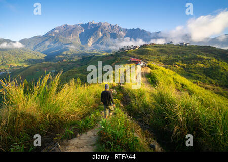 Man Walking, Wandern und Trekking bei Ridge Trail an schönen Morgen Landschaft des Mount Kinabalu in Sabah Kundasang. Stockfoto