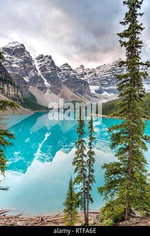 Wolken zwischen Bergspitzen, Reflexion in türkisfarbenen Gletscherseen, Moraine Lake, Tal der zehn Gipfel Stockfoto