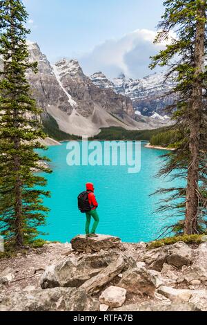 Wanderer am Ufer eines Sees, Berggipfel an der Rückseite, türkisfarbene Gletschersee, Moraine Lake, Tal der zehn Gipfel Stockfoto