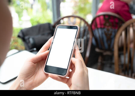 Mockup Bild von Hand white Handy mit leerer Bildschirm mit Frau modernes Cafe. Stockfoto