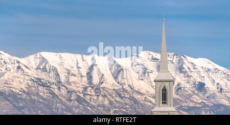 Kirchturm mit Mount Timpanogos Hintergrund. Blick von der schönen weißen Turm einer Kirche in Eagle Mountain, Utah. Mount Timpanogos mit schneebedeckten Stockfoto